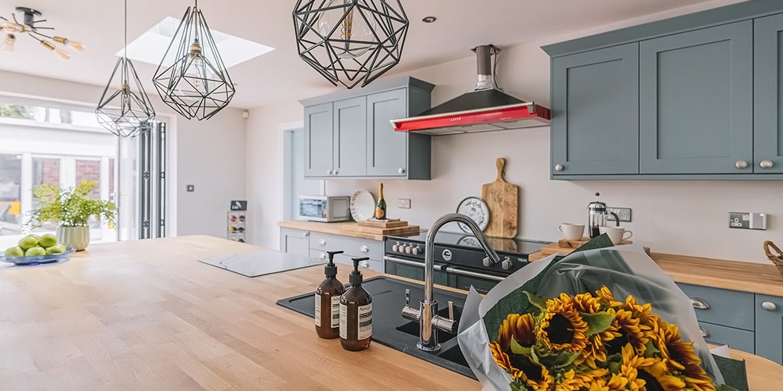 View to the garden from open plan kitchen across the generous island with sink and oak worktops
